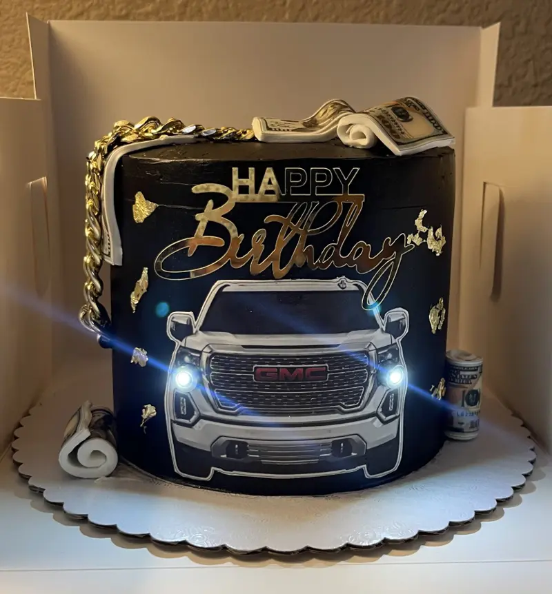 Black Happy Birthday cake with an edible truck image and gold details