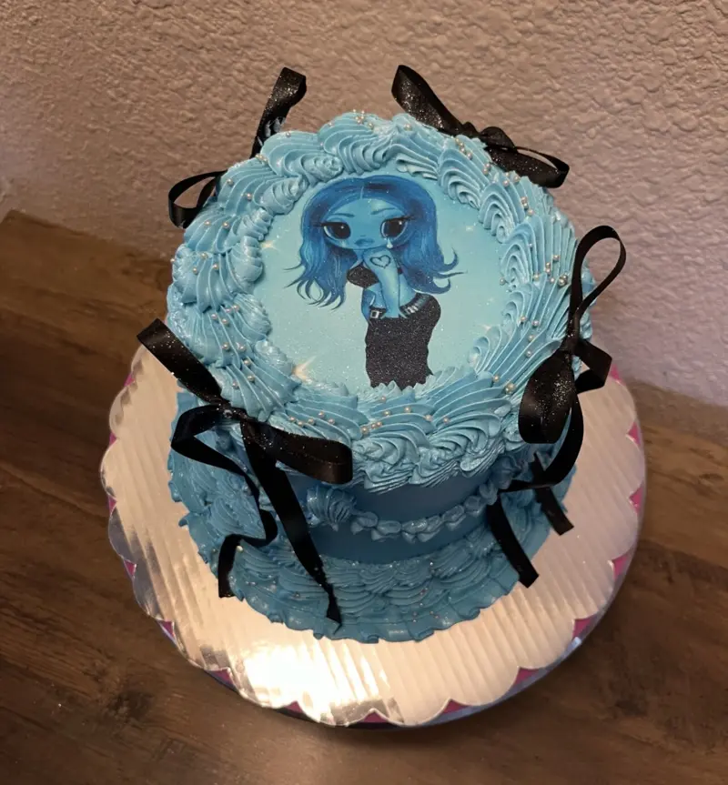 Blue vintage cake with black bows and an edible character image