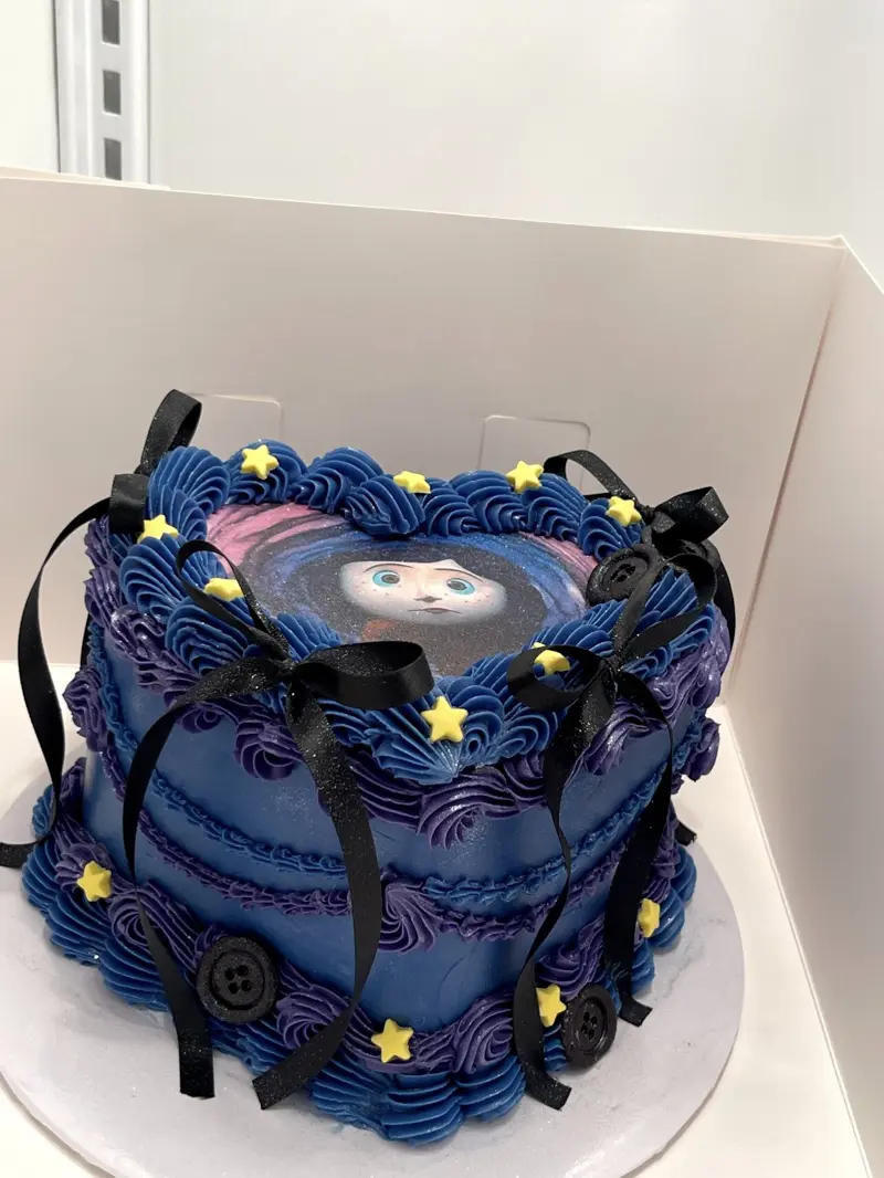 Navy vintage cake with stars, buttons, black bows and an edible character image