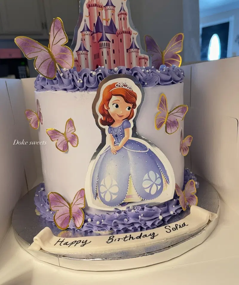 Princess Sofia birthday cake with a castle topper and lilac butterflies