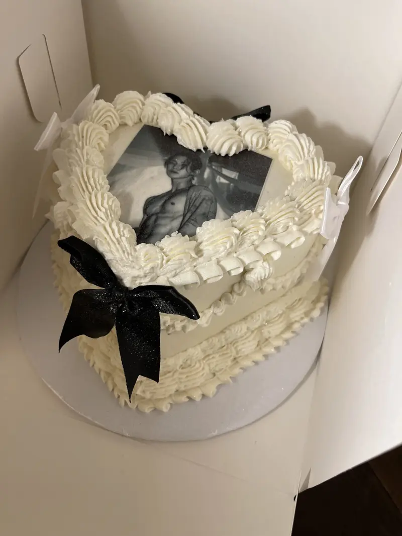White heart-shaped vintage cake with an edible photo and black and white bows